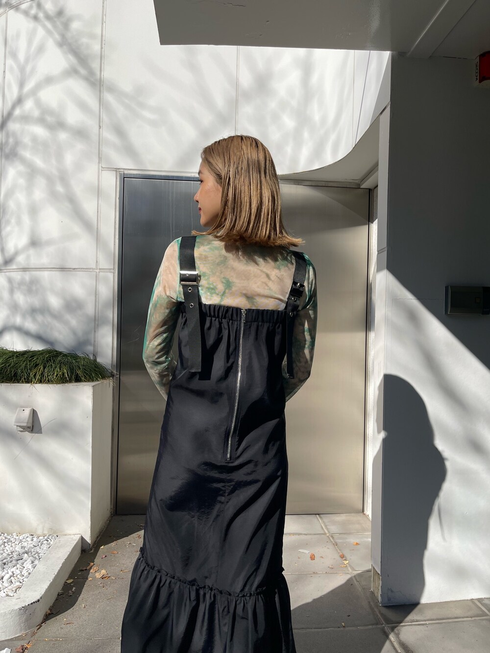 ブラック系のワンピース、ブラック系のショルダーバッグ、ブラック系のブーツを着用したレディースの冬コーディネートの6枚目の写真