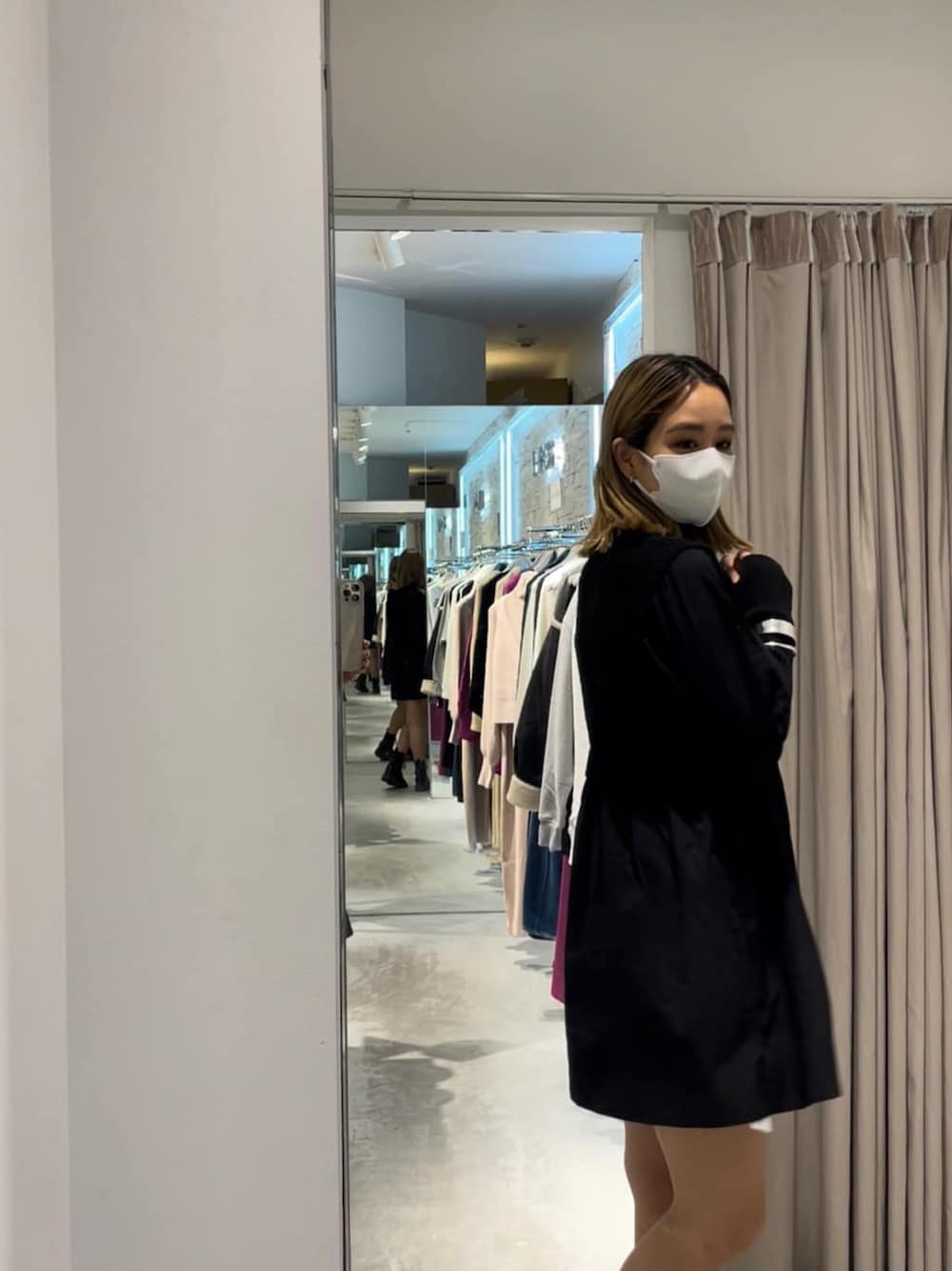 ブラック系のブーツ、ブラック系のワンピース、シルバー系のバングル/リストバンドを着用したレディースの秋コーディネートの2枚目の写真