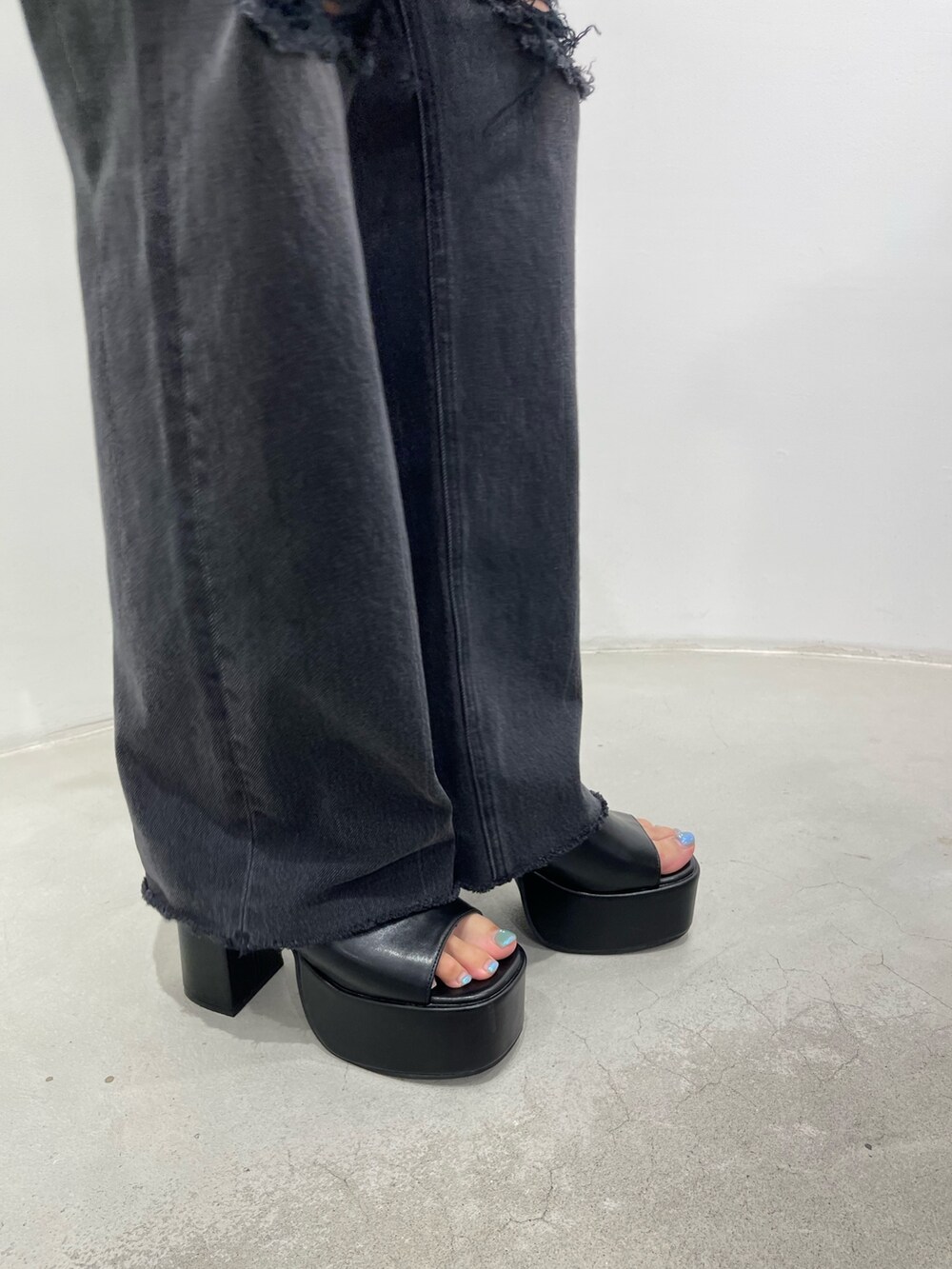 ホワイト系のキャミソール、ブラック系のデニムパンツ、ブラック系のサンダルを着用したレディースの夏コーディネートの7枚目の写真