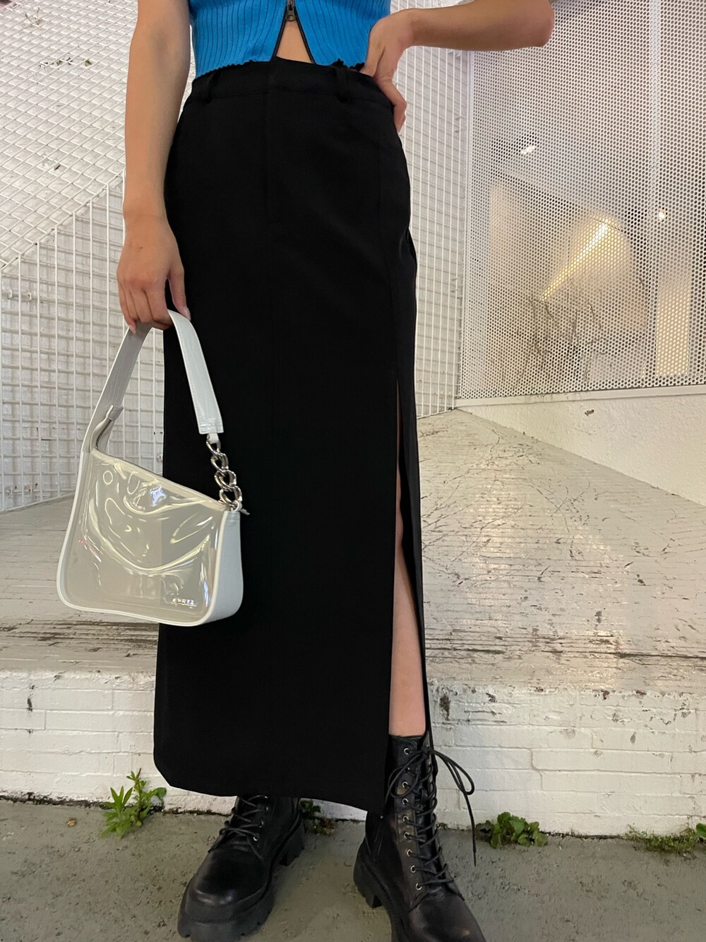 ブラック系のブーツ、ホワイト系のハンドバッグ、ブルー系のタンクトップを着用したレディースの夏コーディネートの6枚目の写真