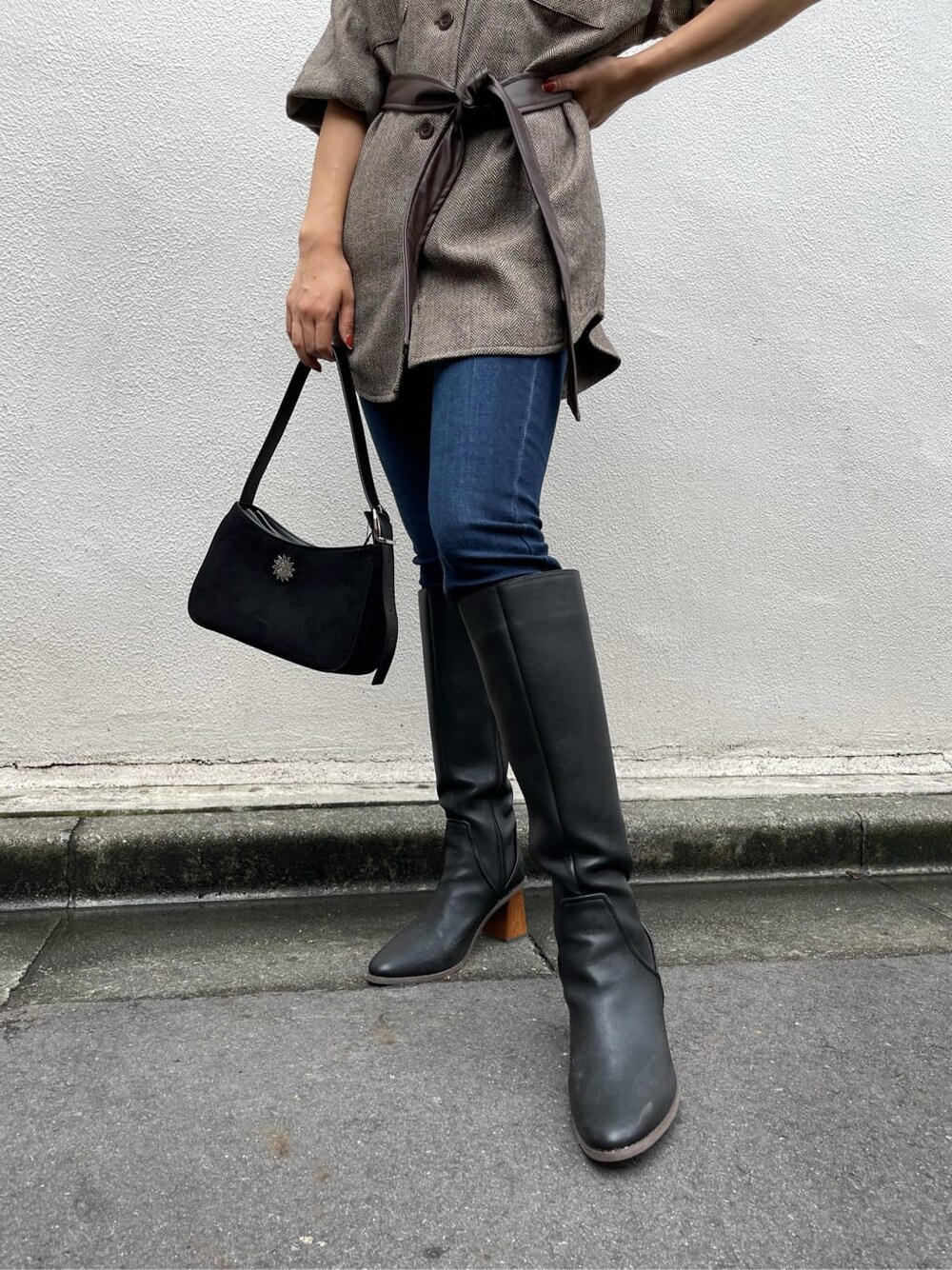 ブラック系のブーツ、ブルー系のデニムパンツ、ブラウン系のその他アウターを着用したレディースの秋コーディネートの5枚目の写真