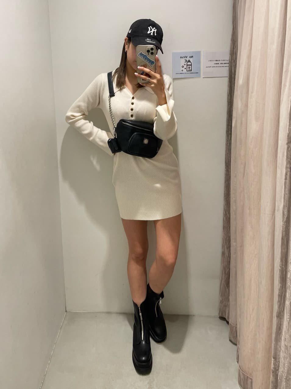 ブラック系のブーツ、ブラック系のボディバッグ/ウエストポーチ、ホワイト系のワンピースを着用したレディースの冬コーディネートの3枚目の写真