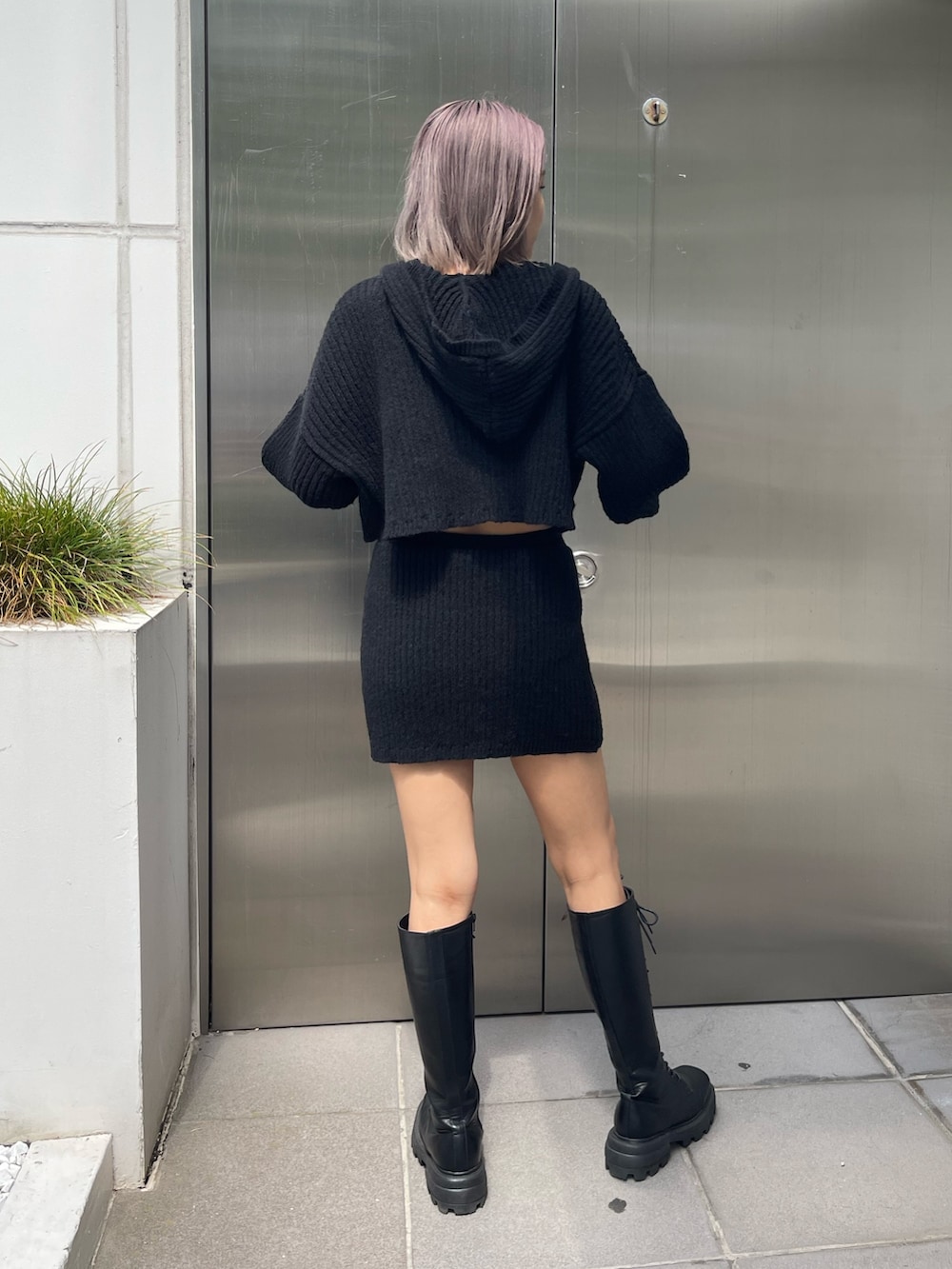 ブラック系のブーツ、ブラック系のカーディガン/ボレロ、ブラック系のスカートを着用したレディースの秋コーディネートの3枚目の写真