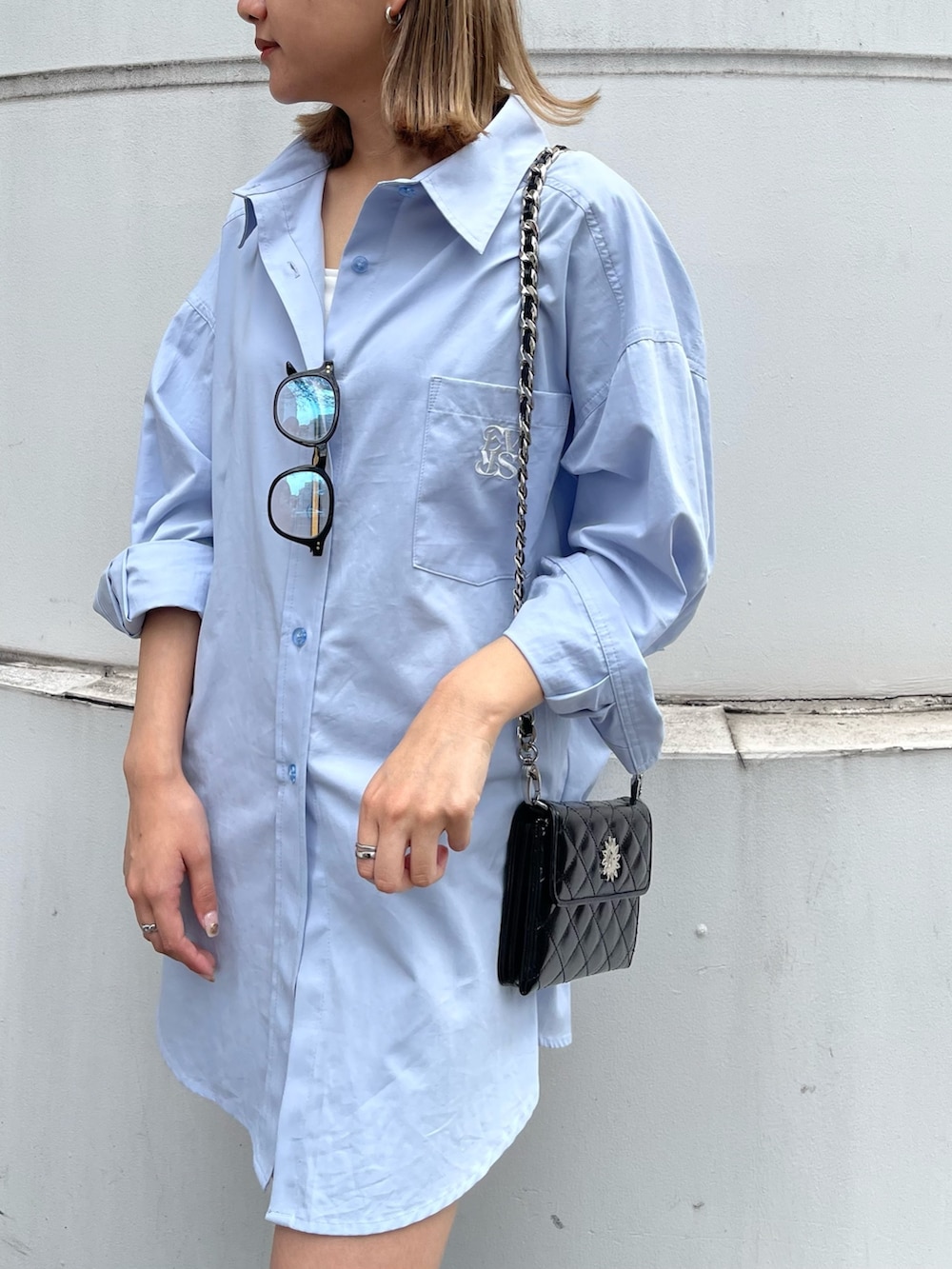 ブラック系のブーツ、ブラック系のショルダーバッグ、ブルー系のシャツ/ブラウスを着用したレディースの春コーディネートの7枚目の写真