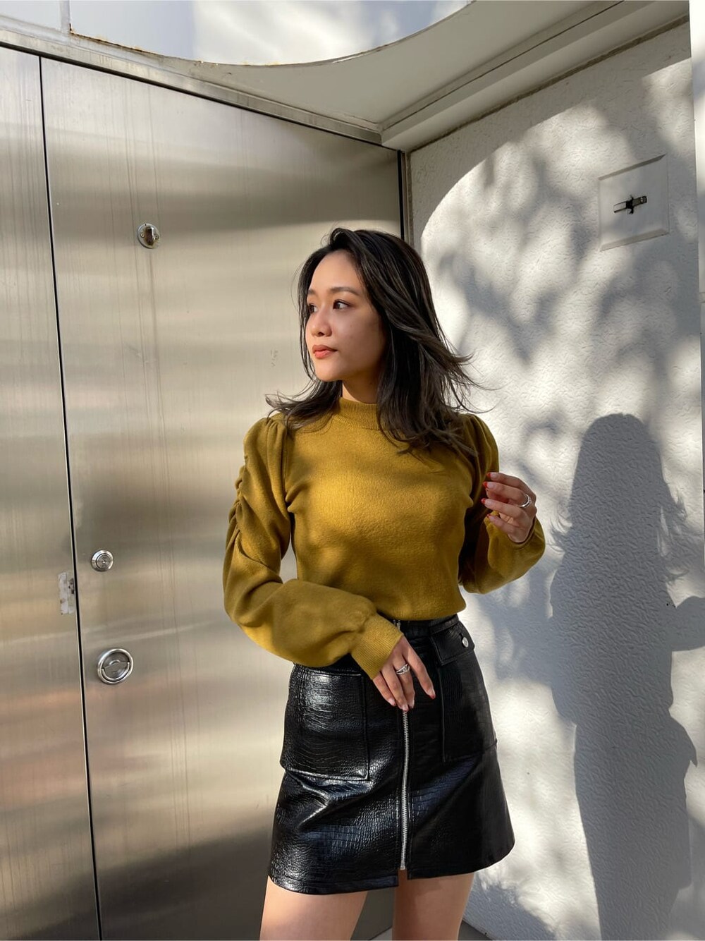 ブラック系のその他アウター、ブラック系のスカート、ブラック系のブーツを着用したレディースの秋コーディネートの4枚目の写真