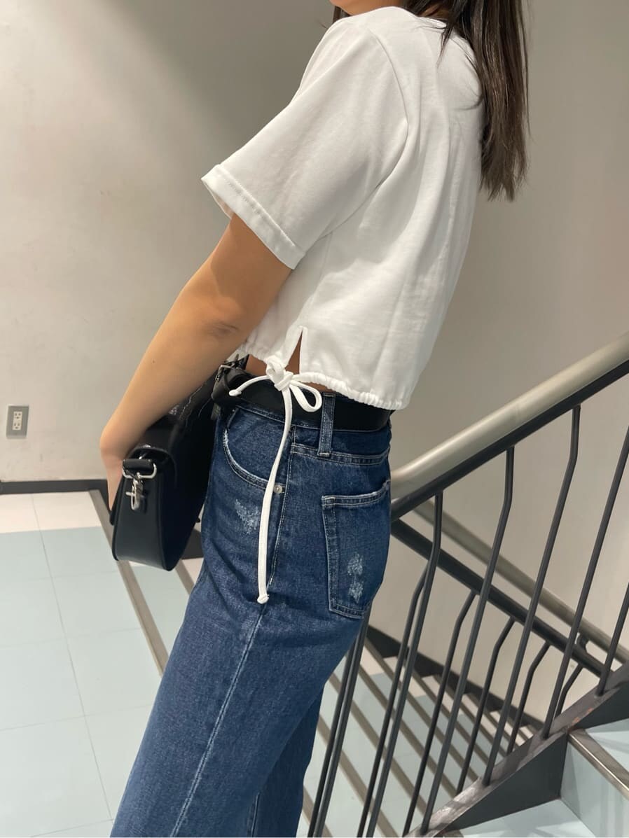 ホワイト系のTシャツ/カットソー、ブラック系のブーツ、ブルー系のデニムパンツを着用したレディースの春コーディネートの4枚目の写真