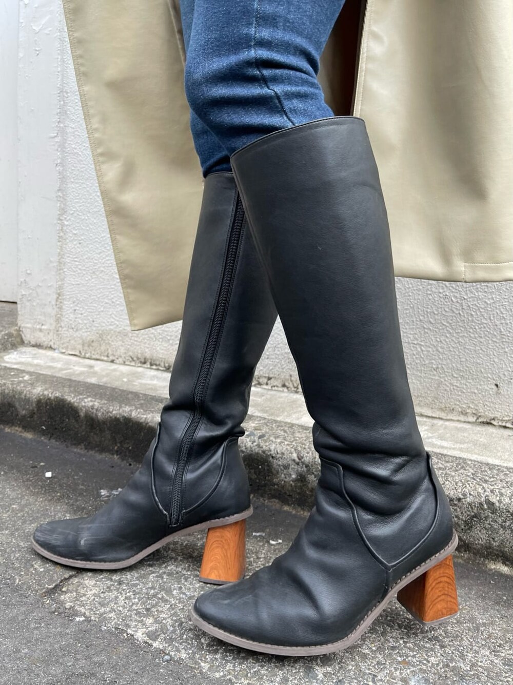 ブラック系のニット/セーター、ホワイト系のトレンチコート、ブラック系のブーツを着用したレディースの冬コーディネートの6枚目の写真