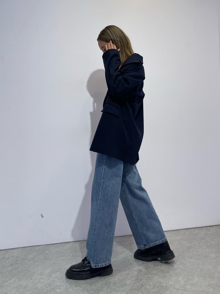 ブラック系のブーツ、ブルー系のデニムパンツ、ブルー系のテーラードジャケットを着用したレディースの秋コーディネートの2枚目の写真