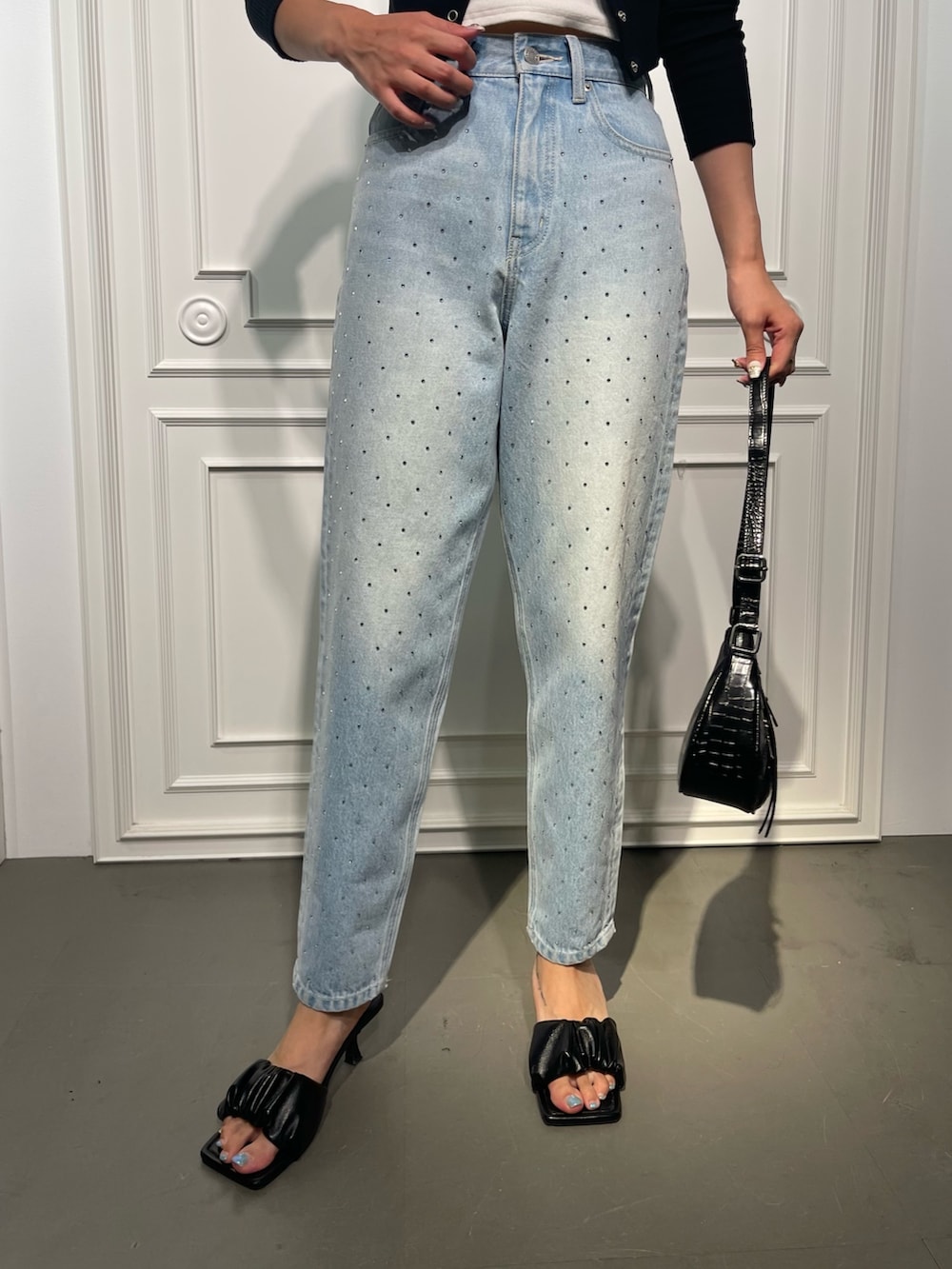 ブラック系のショルダーバッグ、ブルー系のデニムパンツ、ブラック系のサンダルを着用したレディースの夏コーディネートの6枚目の写真