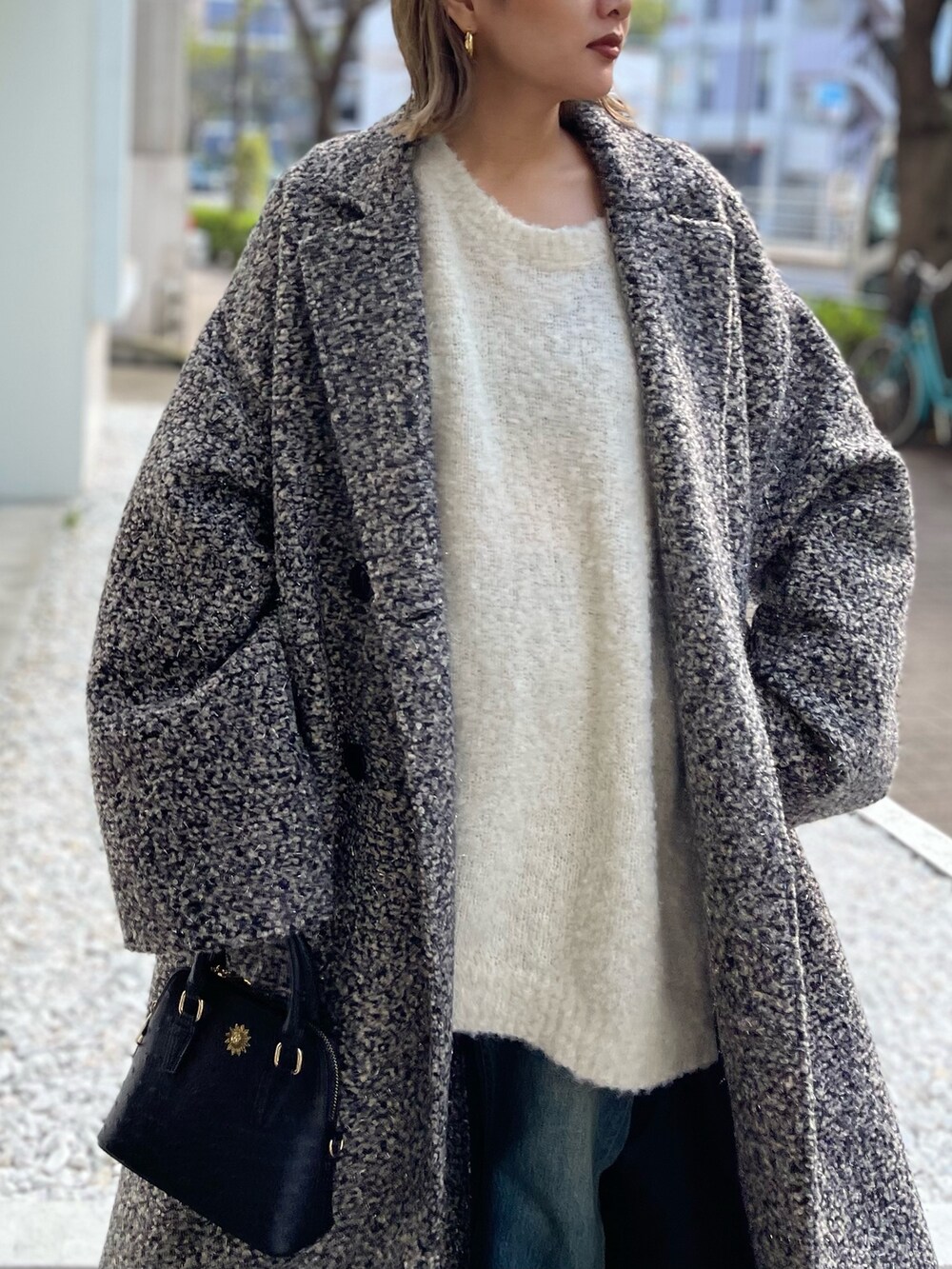 ホワイト系のニット/セーター、ブラック系のショルダーバッグ、その他のチェスターコートを着用したレディースの秋コーディネートの5枚目の写真