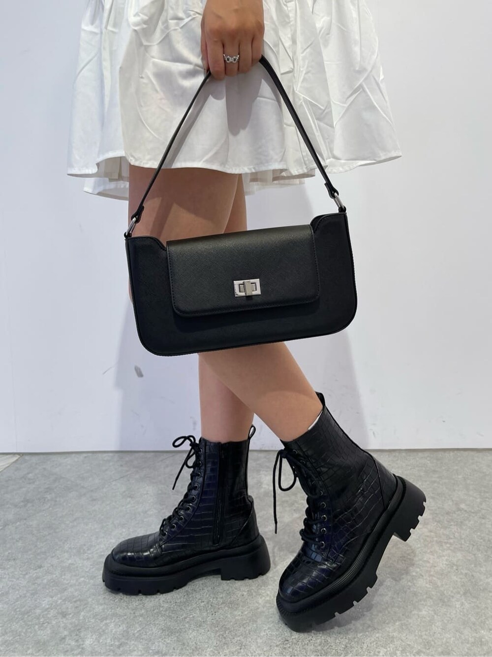 ブラック系のショルダーバッグ、その他のブーツ、ホワイト系のワンピースを着用したレディースの夏コーディネートの6枚目の写真