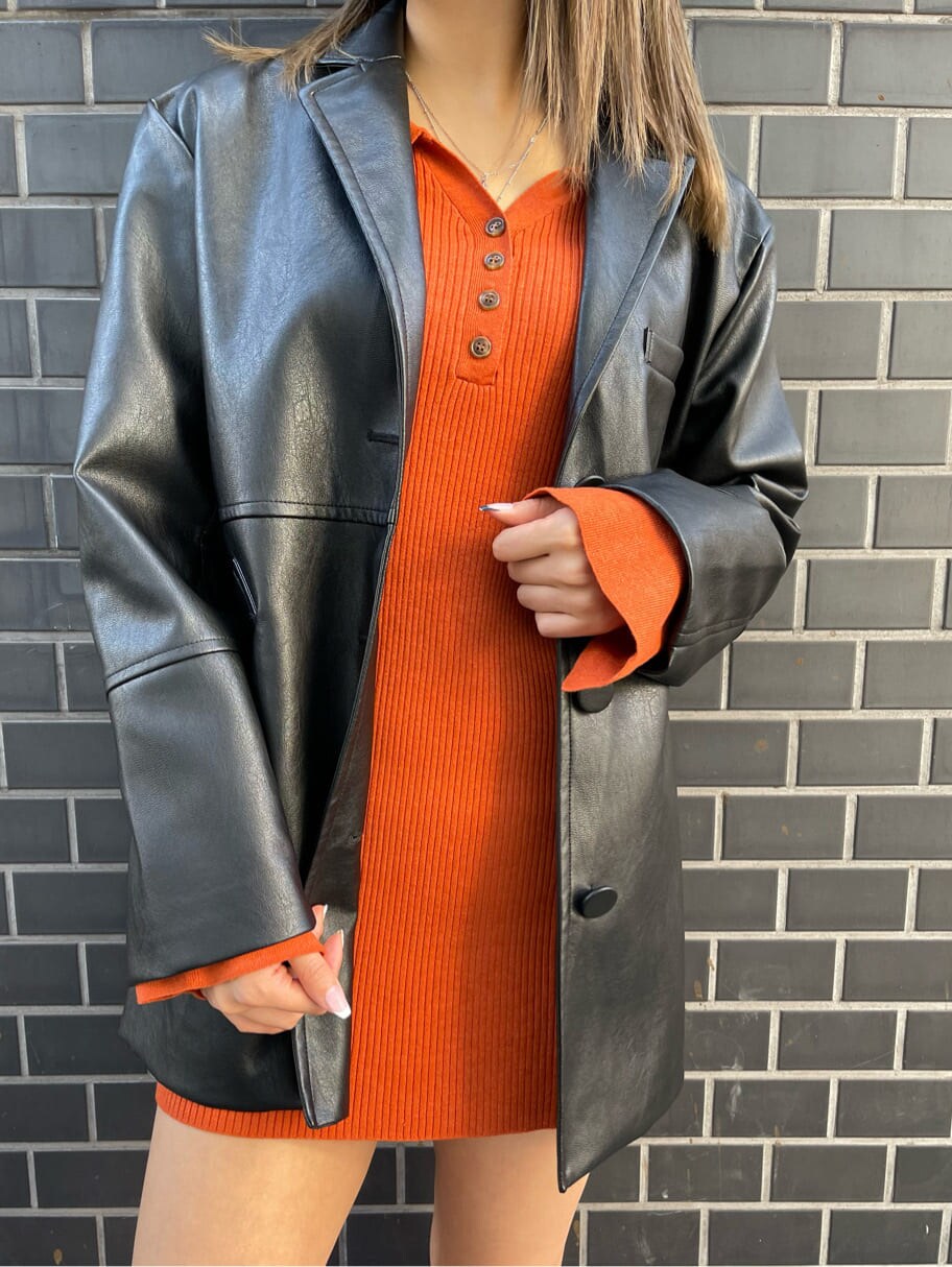 オレンジ系のワンピース、ブラック系のテーラードジャケット、ブラック系のブーツを着用したレディースの冬コーディネートの4枚目の写真