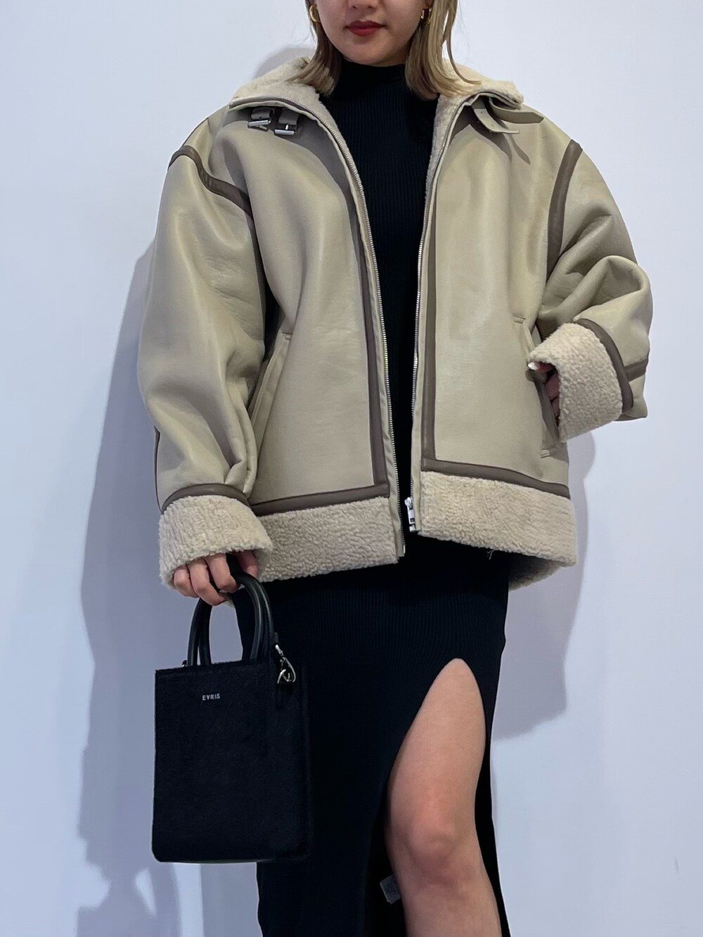 ブラック系のブーツ、ブラック系のショルダーバッグ、ブラック系のワンピースを着用したレディースの冬コーディネートの5枚目の写真