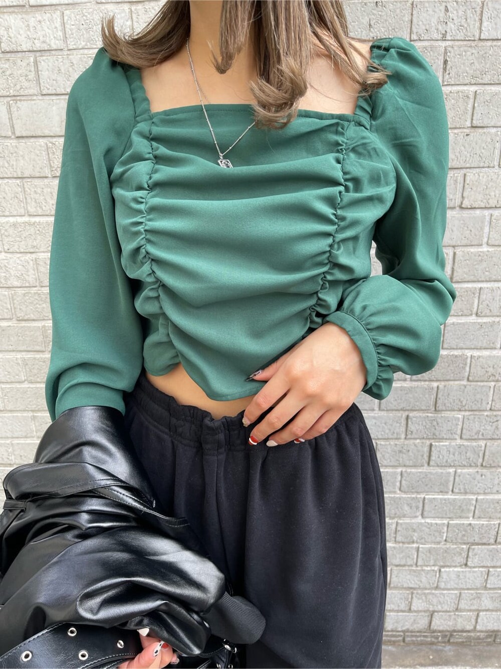 ブラック系のトレンチコート、グリーン系のシャツ/ブラウス、ブラック系のショルダーバッグを着用したレディースの冬コーディネートの5枚目の写真