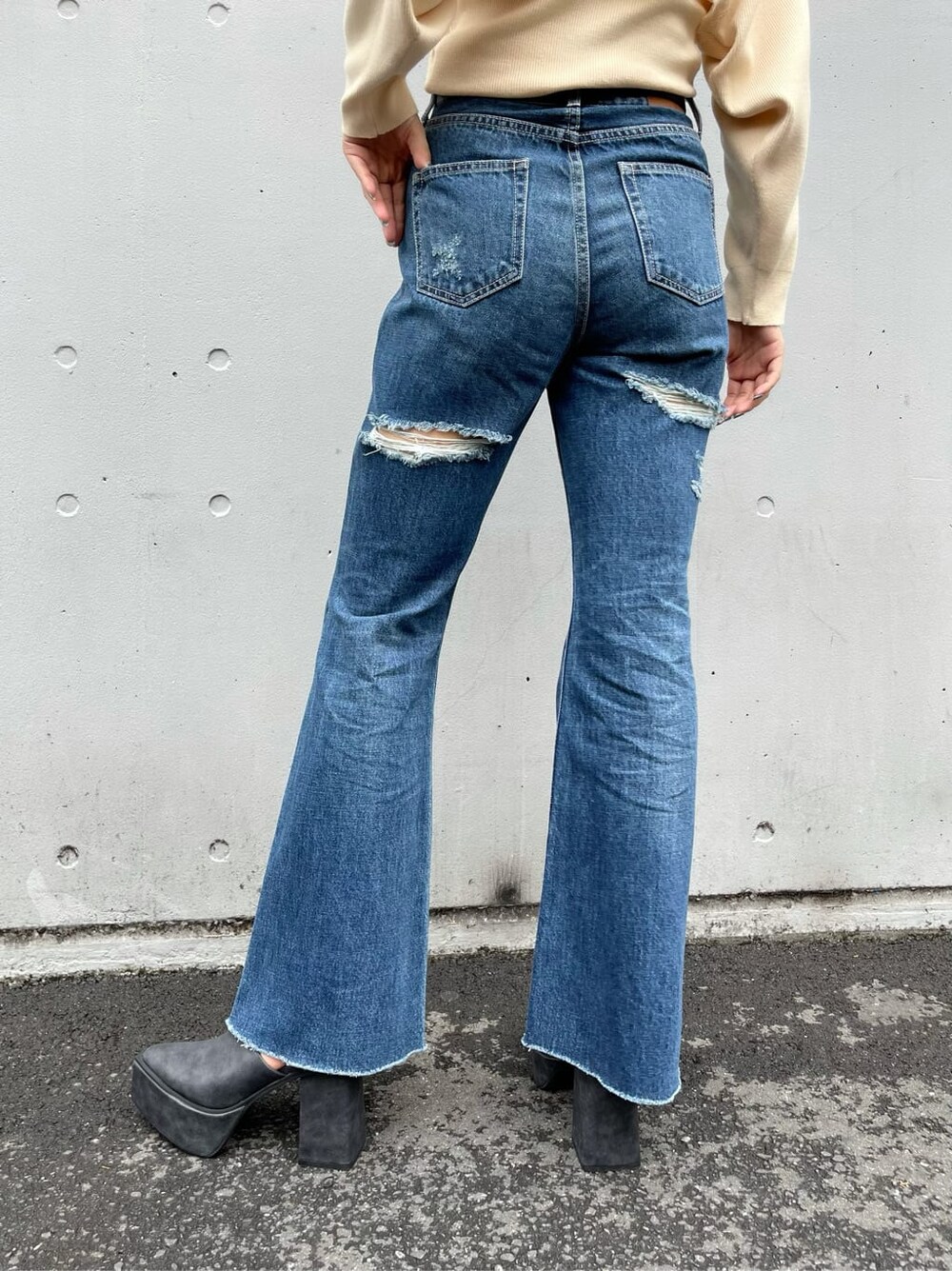 ブラック系のサンダル、ブルー系のデニムパンツ、ホワイト系のベルトを着用したレディースの秋コーディネートの6枚目の写真