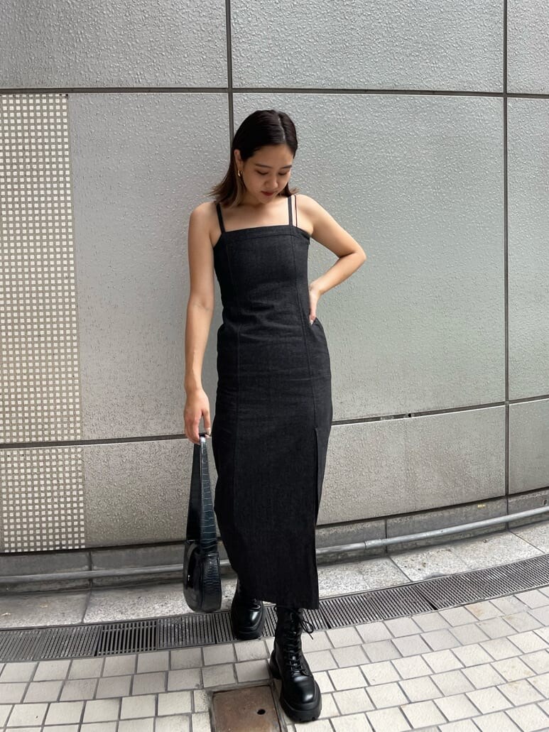 ブラック系のハンドバッグ、ブラック系のワンピース、ブラック系のブーツを着用したレディースの夏コーディネートの2枚目の写真