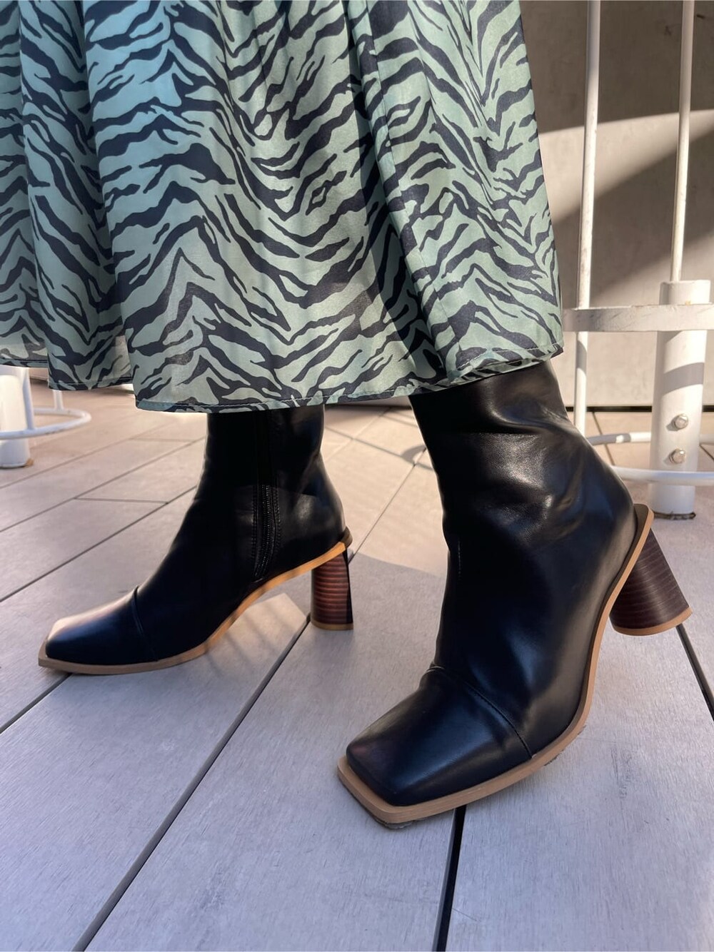 ブラック系のブーツ、グリーン系のワンピース、ブラック系のニット/セーターを着用したレディースの冬コーディネートの8枚目の写真