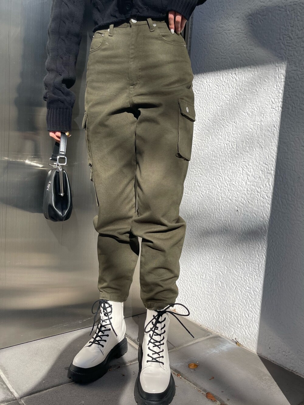 ブラック系のショルダーバッグ、ブラック系のカーディガン/ボレロ、ホワイト系のブーツを着用したレディースの冬コーディネートの7枚目の写真