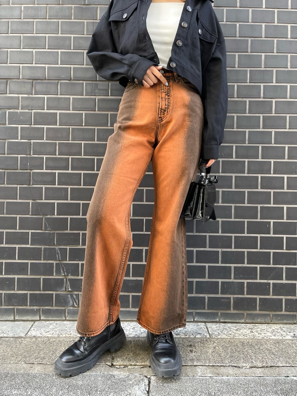 ブラック系のブルゾン、ブラック系のブーツ、ホワイト系のキャミソールを着用したレディースの春コーディネートの7枚目の写真