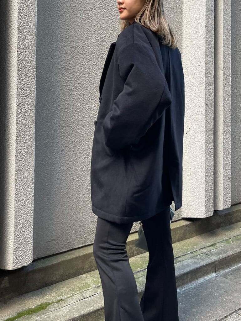 ブラック系のブーツ、ブラック系のその他アウター、グリーン系のショルダーバッグを着用したレディースの秋コーディネートの6枚目の写真