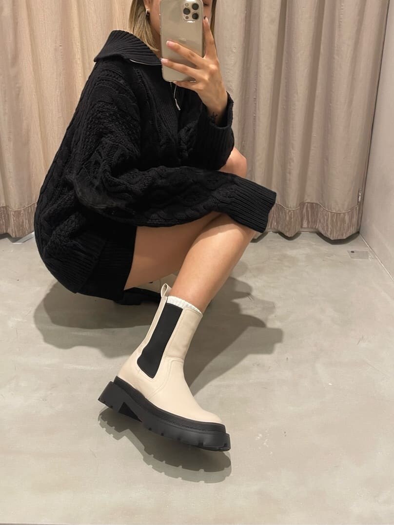 ブラック系のその他パンツ、ホワイト系のブーツ、ブラック系のニット/セーターを着用したレディースの秋コーディネートの8枚目の写真