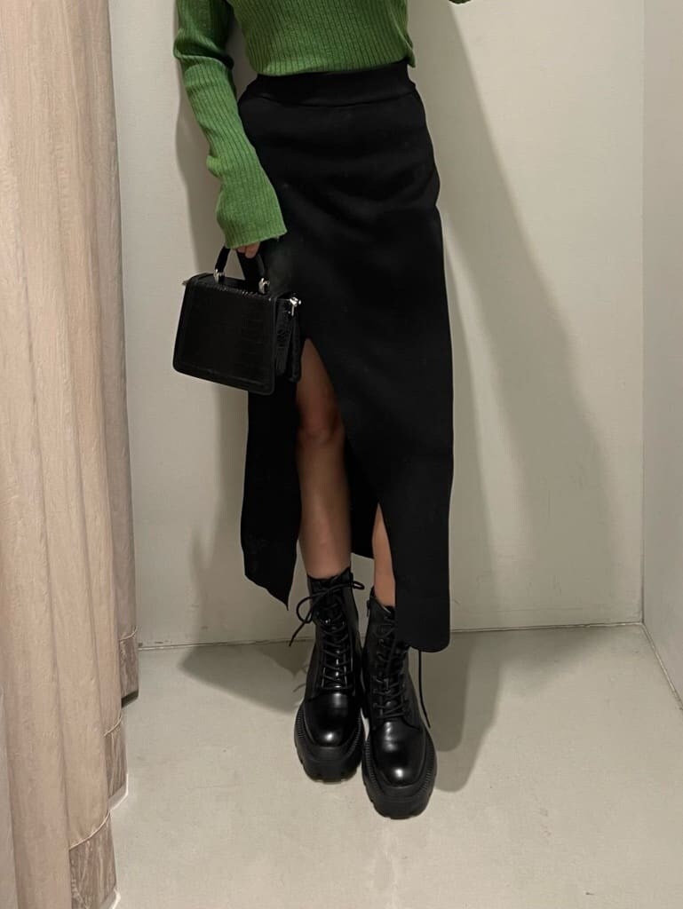 ブラック系のブーツ、グリーン系のニット/セーター、ブラック系のハンドバッグを着用したレディースの秋コーディネートの6枚目の写真
