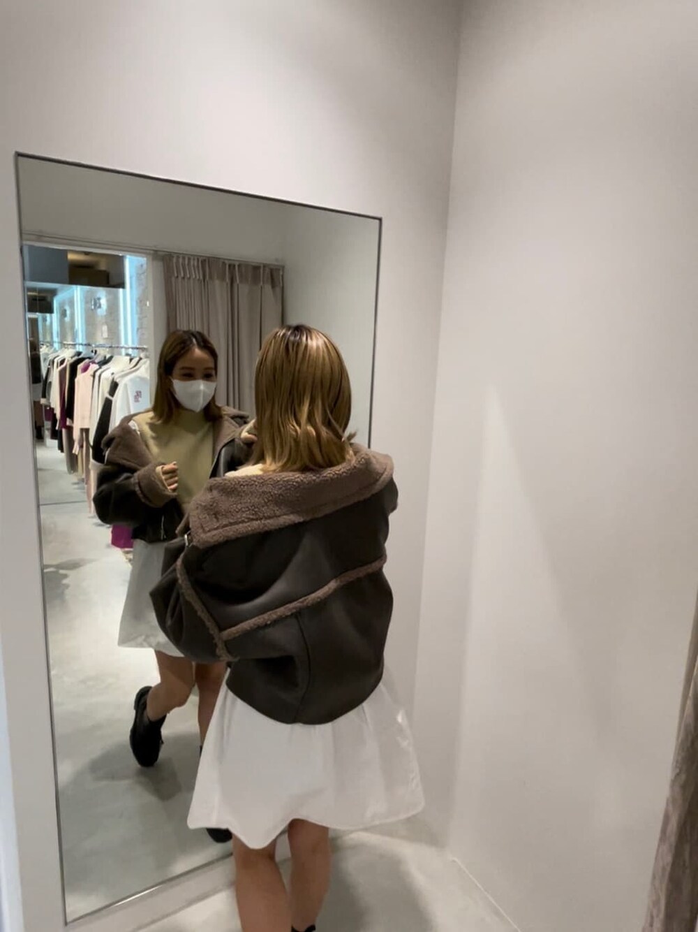 ブラック系のブーツ、グリーン系のブルゾン、ホワイト系のワンピースを着用したレディースの秋コーディネートの3枚目の写真