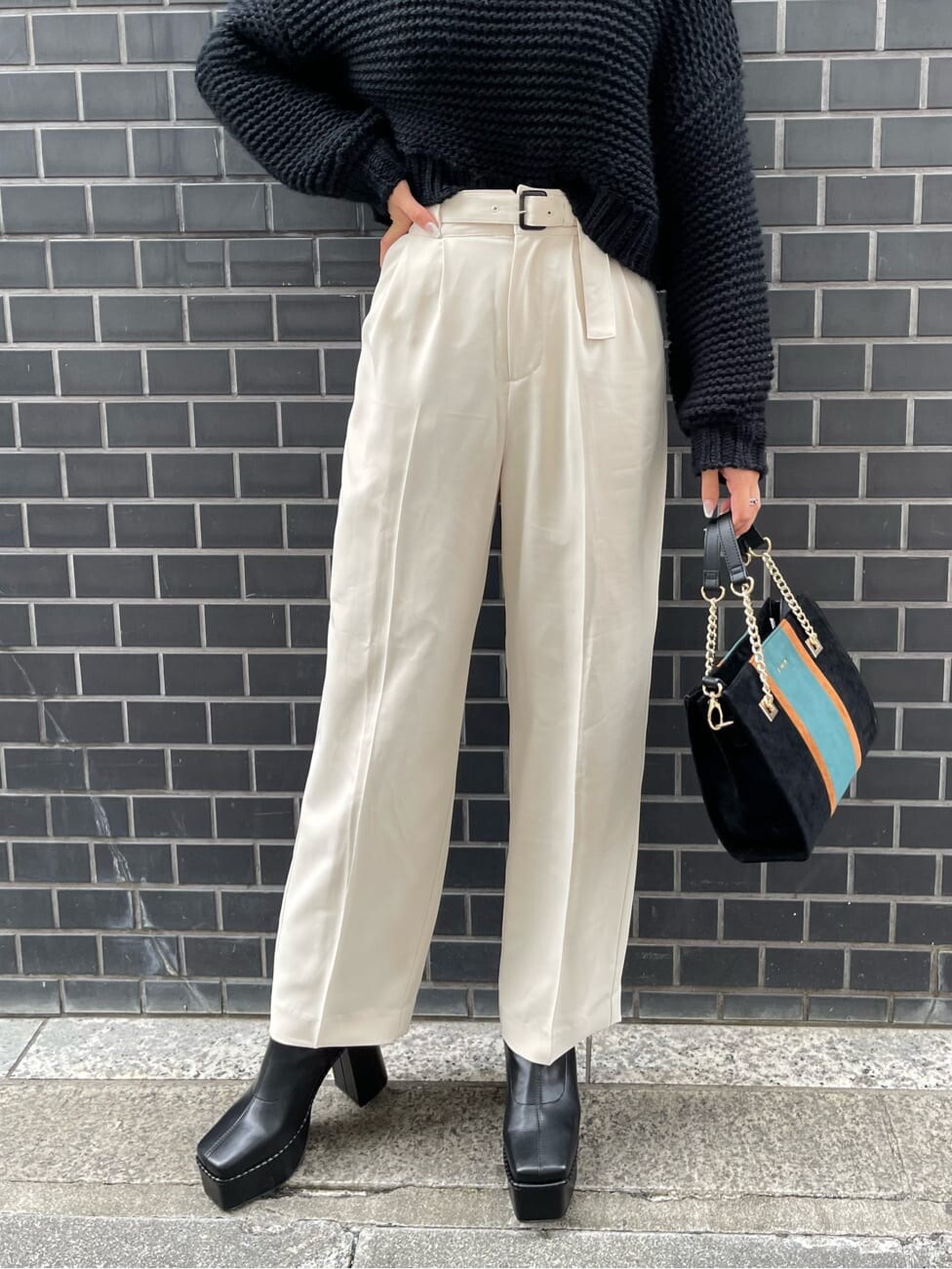 ブラック系のブーツ、ブラック系のニット/セーター、ブラック系のショルダーバッグを着用したレディースの冬コーディネートの5枚目の写真