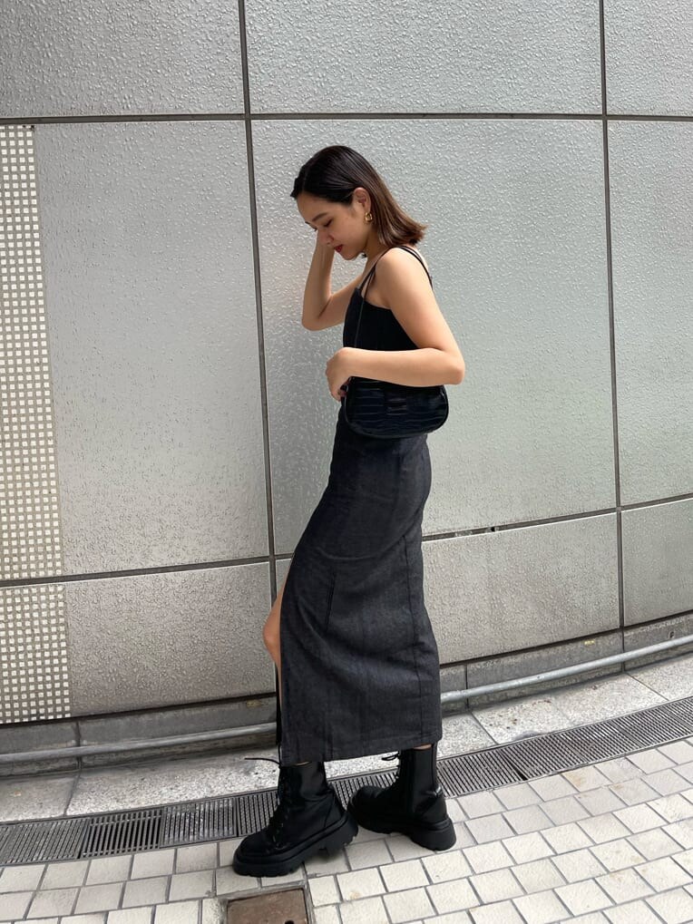 ブラック系のハンドバッグ、ブラック系のワンピース、ブラック系のブーツを着用したレディースの夏コーディネートの6枚目の写真