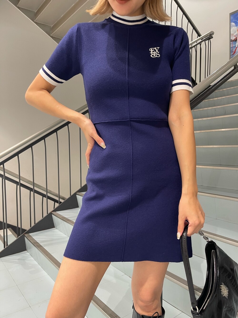 ブルー系のワンピース、ブラック系のブーツ、ブラック系のハンドバッグを着用したレディースの夏コーディネートの7枚目の写真