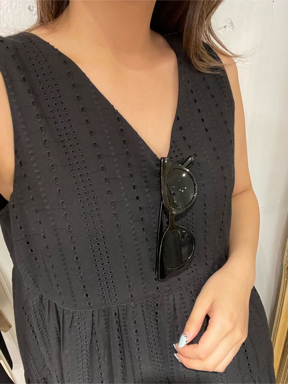 ベージュ系のショルダーバッグ、ブラック系のワンピース、イエロー系のサンダルを着用したレディースの春コーディネートの5枚目の写真