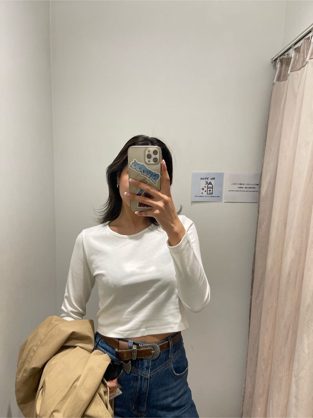 ブラック系のパンプス、ベージュ系のトレンチコート、ブルー系のデニムパンツを着用したレディースの冬コーディネートの6枚目の写真