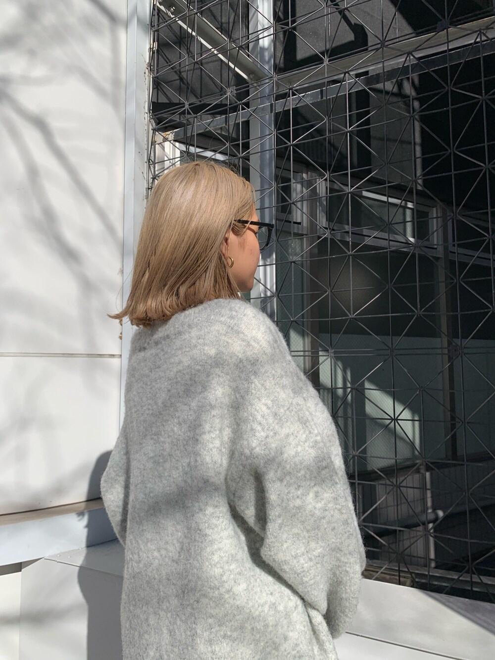 グレー系のカーディガン/ボレロ、ブラック系のブーツ、ホワイト系のTシャツ/カットソーを着用したレディースの冬コーディネートの6枚目の写真