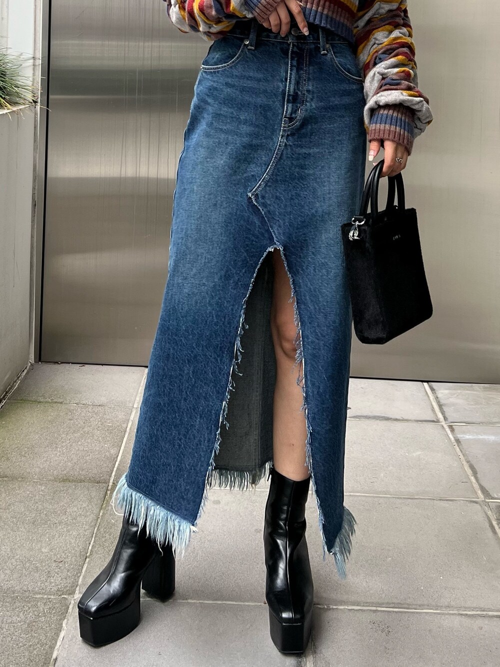 ブルー系のデニムスカート、その他のニット/セーター、ブラック系のブーツを着用したレディースの秋コーディネートの5枚目の写真