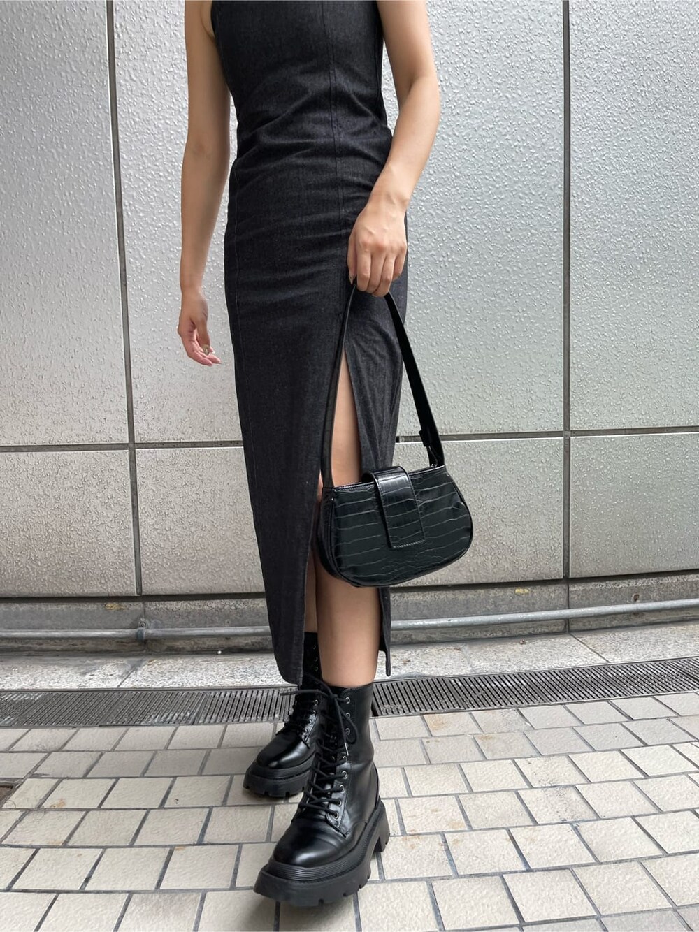 ブラック系のハンドバッグ、ブラック系のワンピース、ブラック系のブーツを着用したレディースの夏コーディネートの8枚目の写真