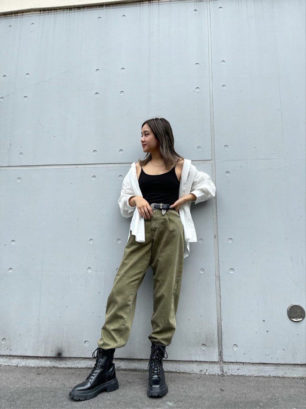 ブラック系のブーツ、ホワイト系のシャツ/ブラウス、ベージュ系のデニムパンツを着用したレディースの夏コーディネートの2枚目の写真