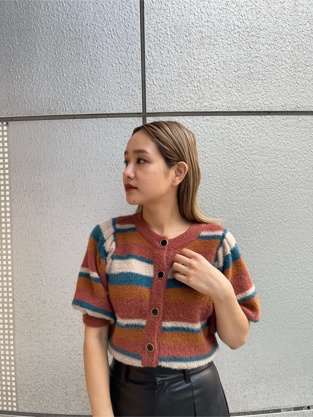 ブラック系のブーツ、ブラック系のショルダーバッグ、ブラック系のスカートを着用したレディースの秋コーディネートの5枚目の写真