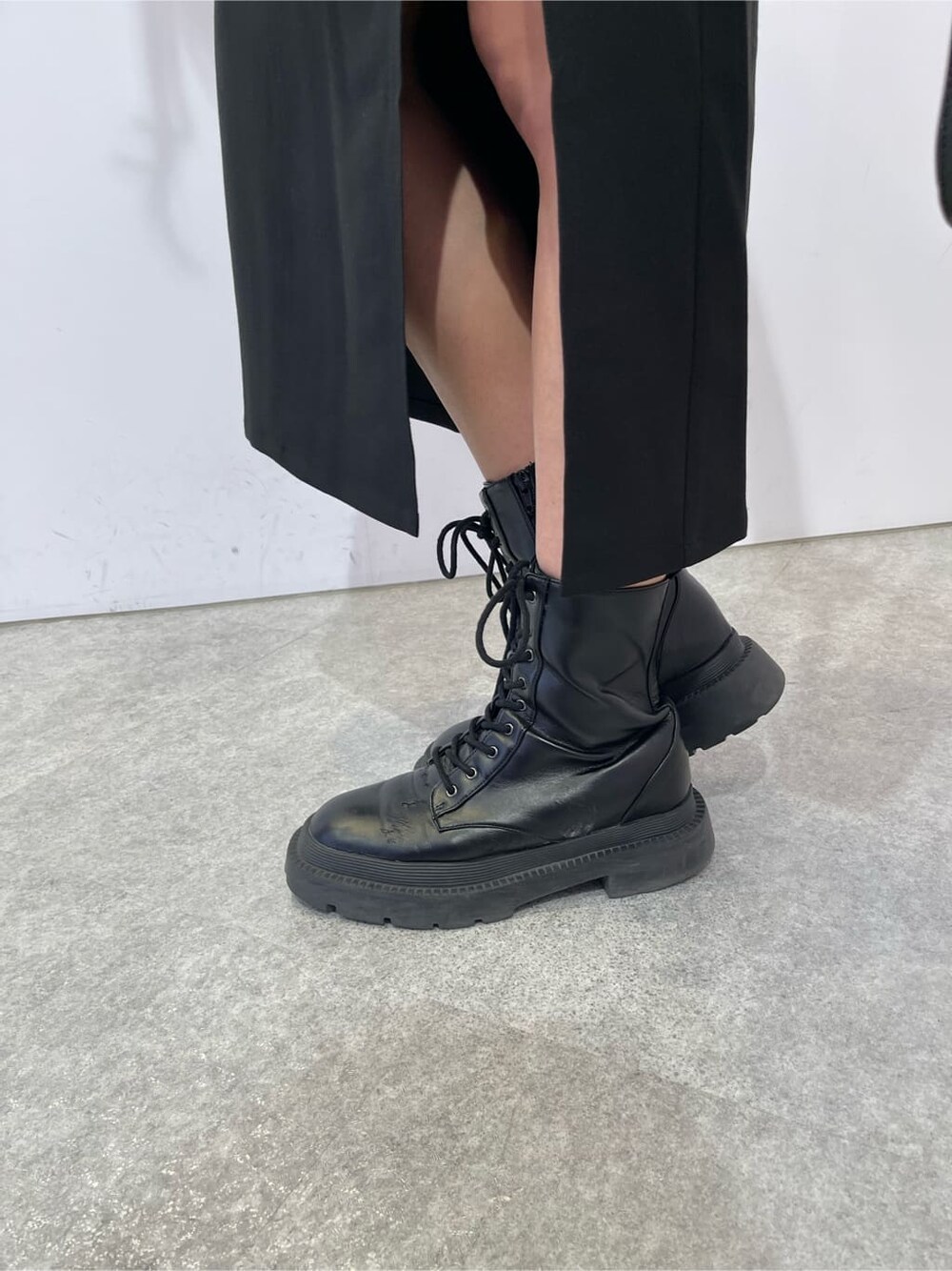 ブラック系のスカート、ブラック系のブーツ、ブラック系のショルダーバッグを着用したレディースの夏コーディネートの8枚目の写真