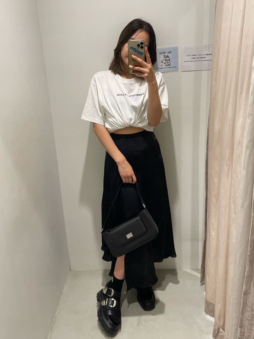 ブラック系のショルダーバッグ、ホワイト系のTシャツ/カットソー、ブラック系のスカートを着用したレディースの春コーディネートの2枚目の写真