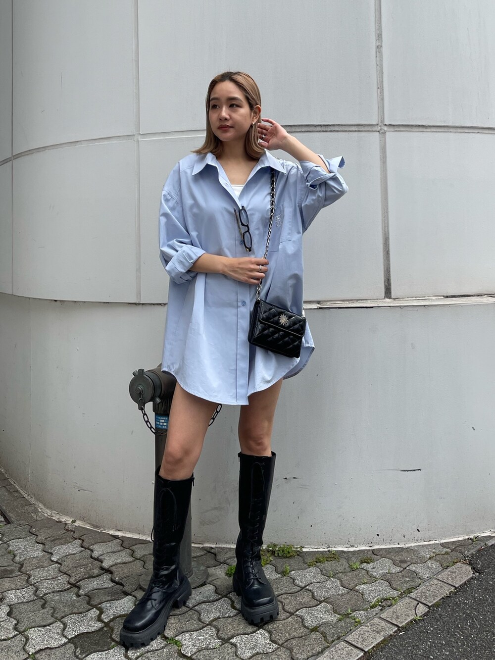 ブラック系のブーツ、ブラック系のショルダーバッグ、ブルー系のシャツ/ブラウスを着用したレディースの春コーディネートの2枚目の写真