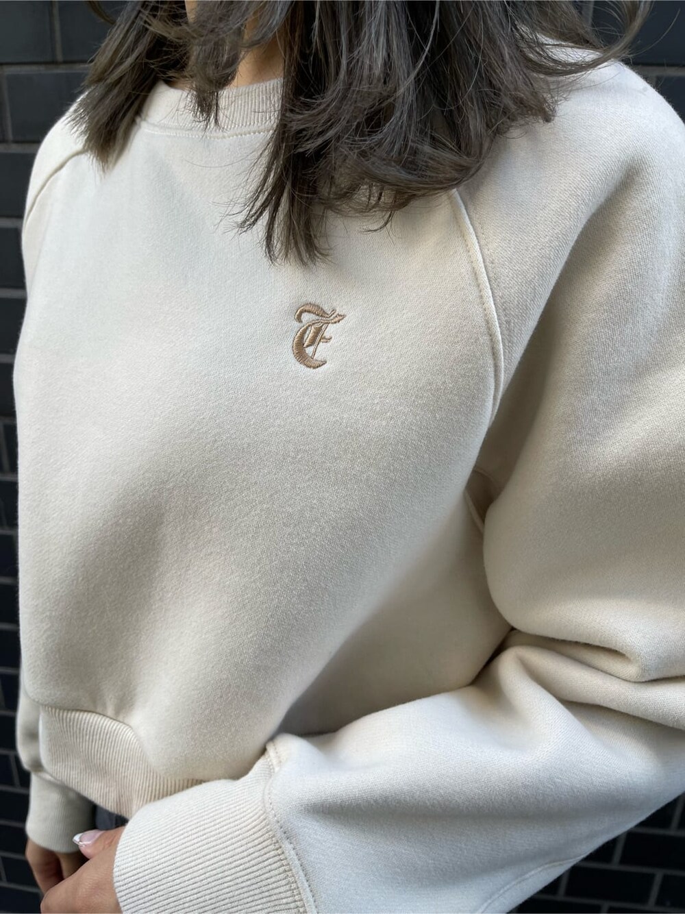 ブラック系のデニムパンツ、ブラック系のブーツ、ホワイト系のスウェットを着用したレディースの冬コーディネートの7枚目の写真