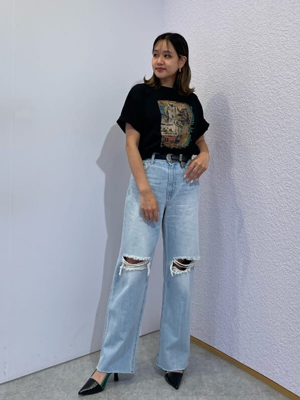 イエロー系のサンダル、ブルー系のデニムパンツ、ブラック系のTシャツ/カットソーを着用したレディースの夏コーディネートの2枚目の写真