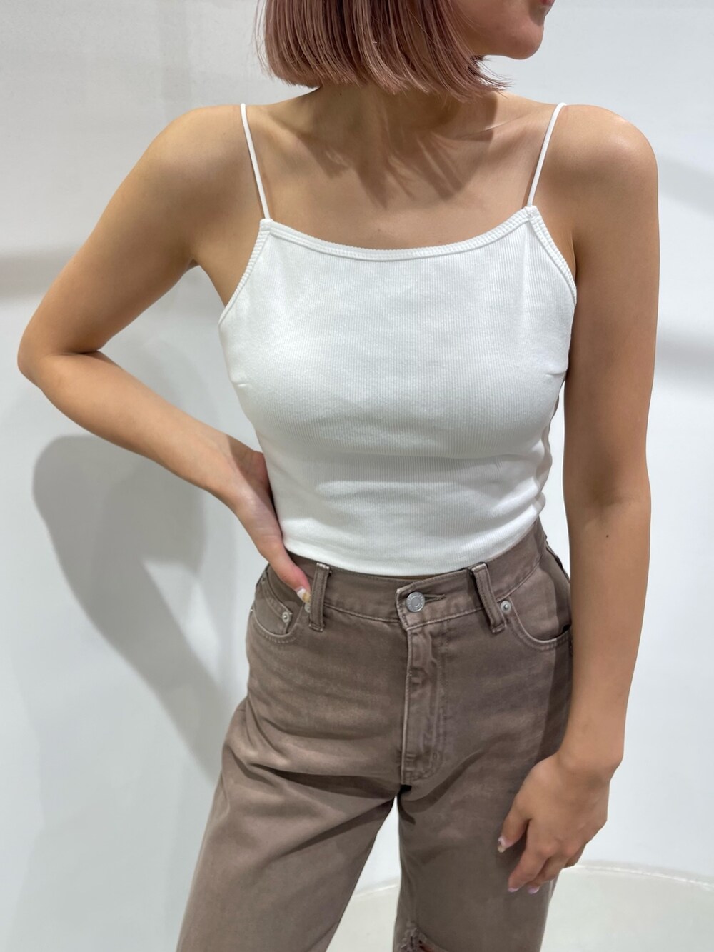 ホワイト系のキャミソール、ブラック系のデニムパンツ、ブラック系のサンダルを着用したレディースの夏コーディネートの8枚目の写真