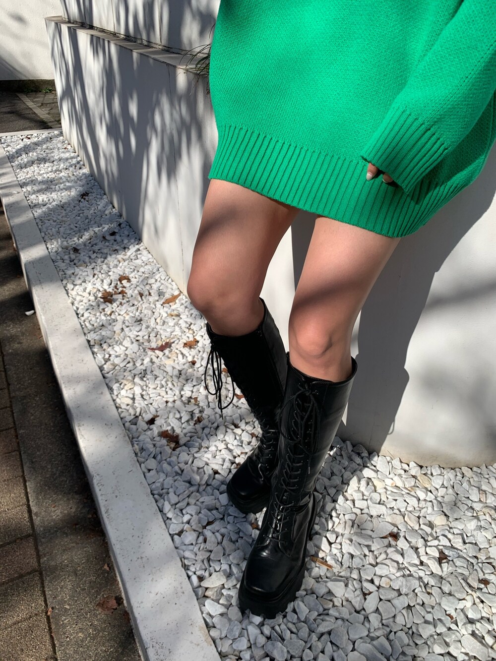 ブラック系のブーツ、グリーン系のニット/セーターを着用したレディースの冬コーディネートの4枚目の写真
