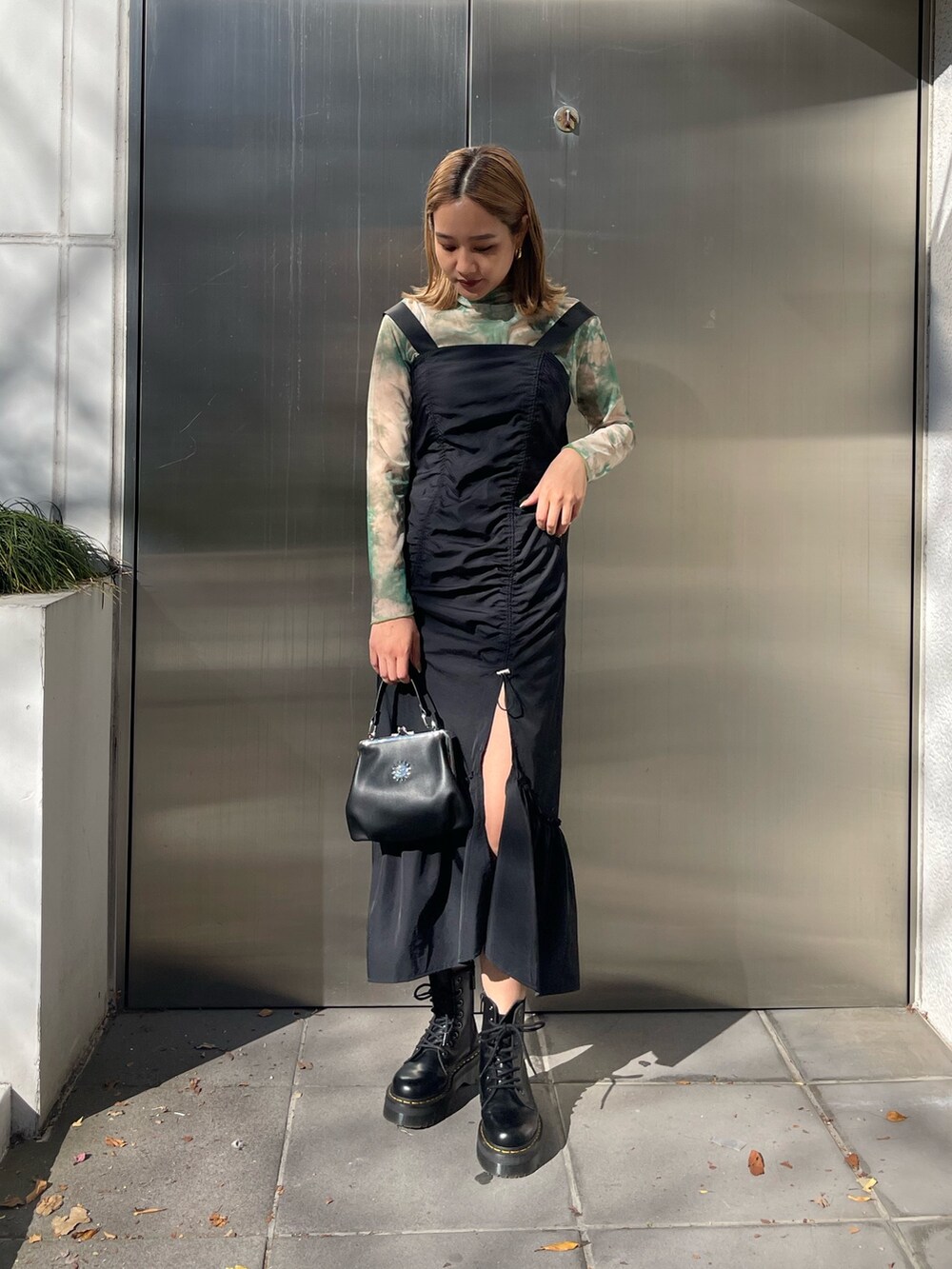 ブラック系のワンピース、ブラック系のショルダーバッグ、ブラック系のブーツを着用したレディースの冬コーディネートの2枚目の写真