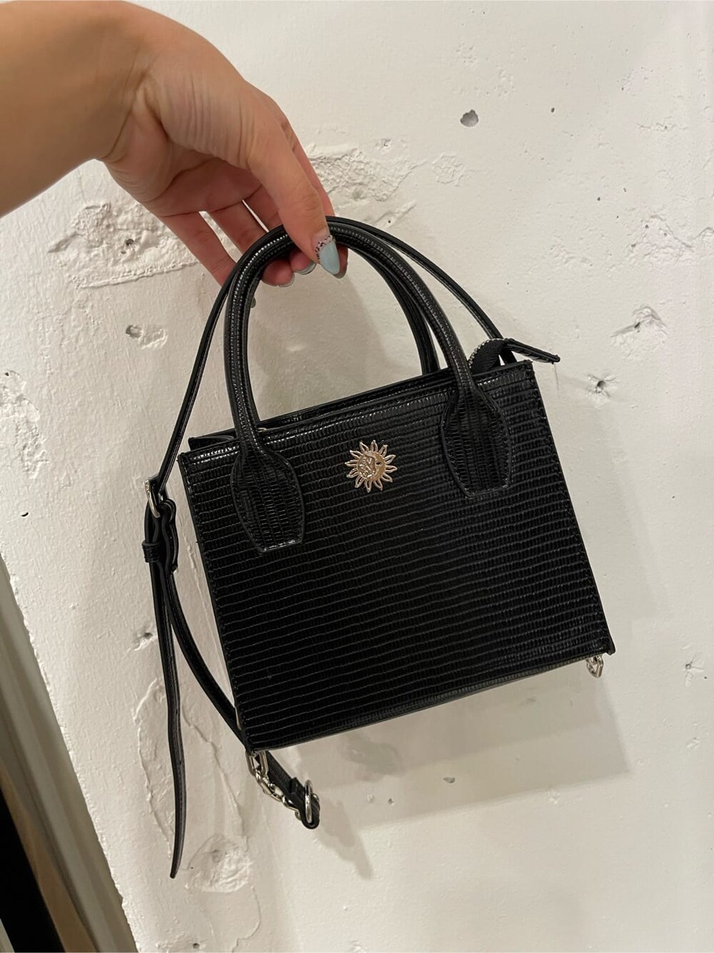 ブラック系のブーツ、ベージュ系のデニムパンツ、ブラック系のニット/セーターを着用したレディースの春コーディネートの7枚目の写真