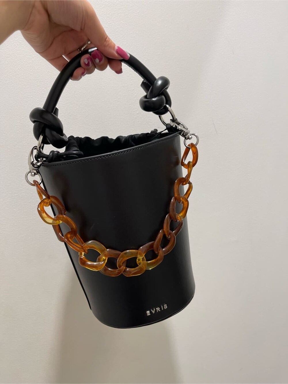 ブラック系のスカート、ホワイト系のTシャツ/カットソー、ブラック系のブーツを着用したレディースの春コーディネートの8枚目の写真