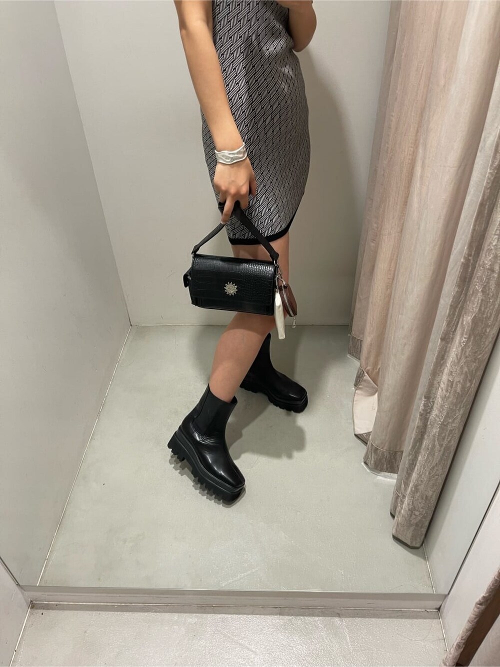 ブラック系のブーツ、ブラック系のワンピース、ブラック系のキャップを着用したレディースの夏コーディネートの7枚目の写真