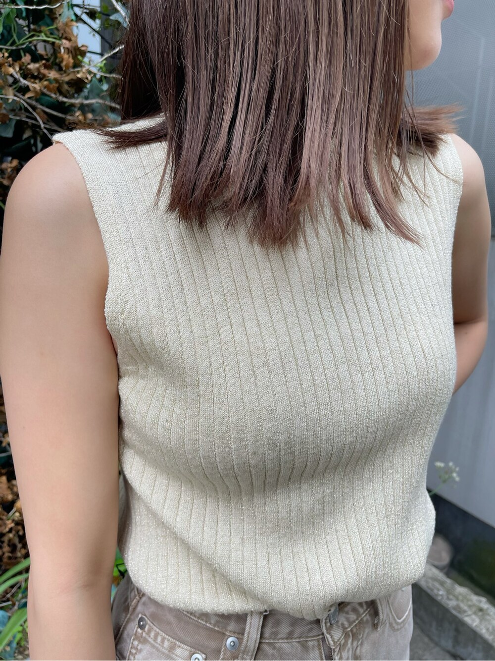 ベージュ系のデニムパンツ、ホワイト系のタンクトップ、ホワイト系のサンダルを着用したレディースの春コーディネートの4枚目の写真