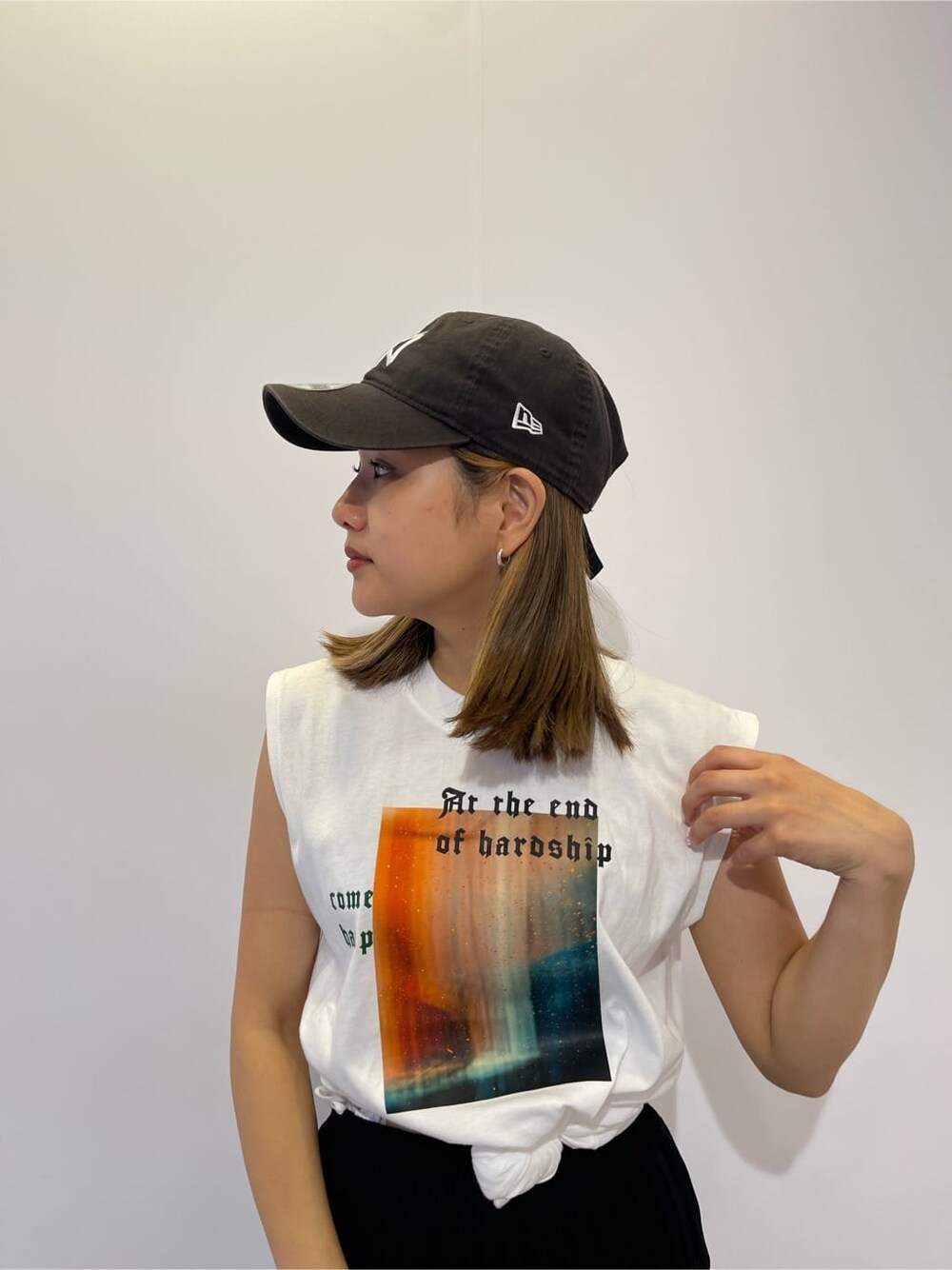 ホワイト系のTシャツ/カットソー、ブラック系のスカート、ベージュ系のショルダーバッグを着用したレディースの夏コーディネートの4枚目の写真